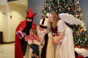 Three people in a devil, santa claus, and angel costumes